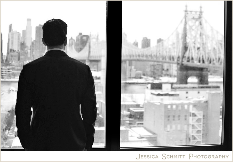 NYC groom looking out the window at the city skyline